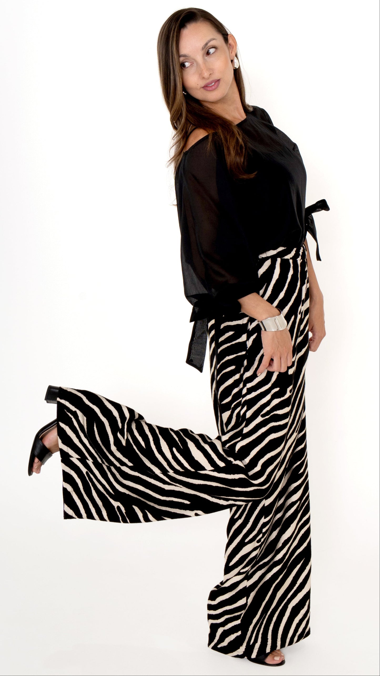 elegante ausgefallene Damenbekleidung in schwarz weiß: Modisch feminines Outfit bestehend aus einer weiten Zebra Print Hose und einer schwarzen Chiffonbluse mit Schleifen am Ärmel, Halbarm